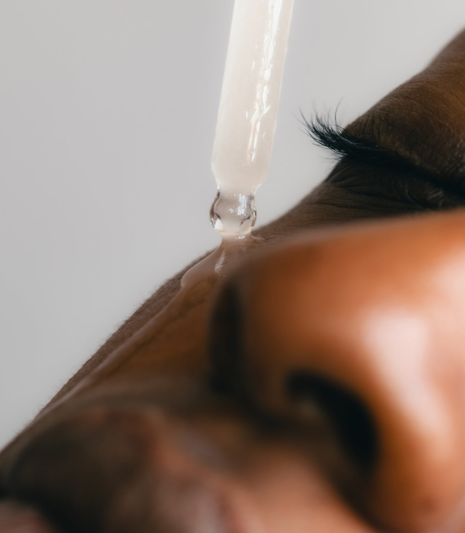 Close-up of a dropper with liquid being applied to skin