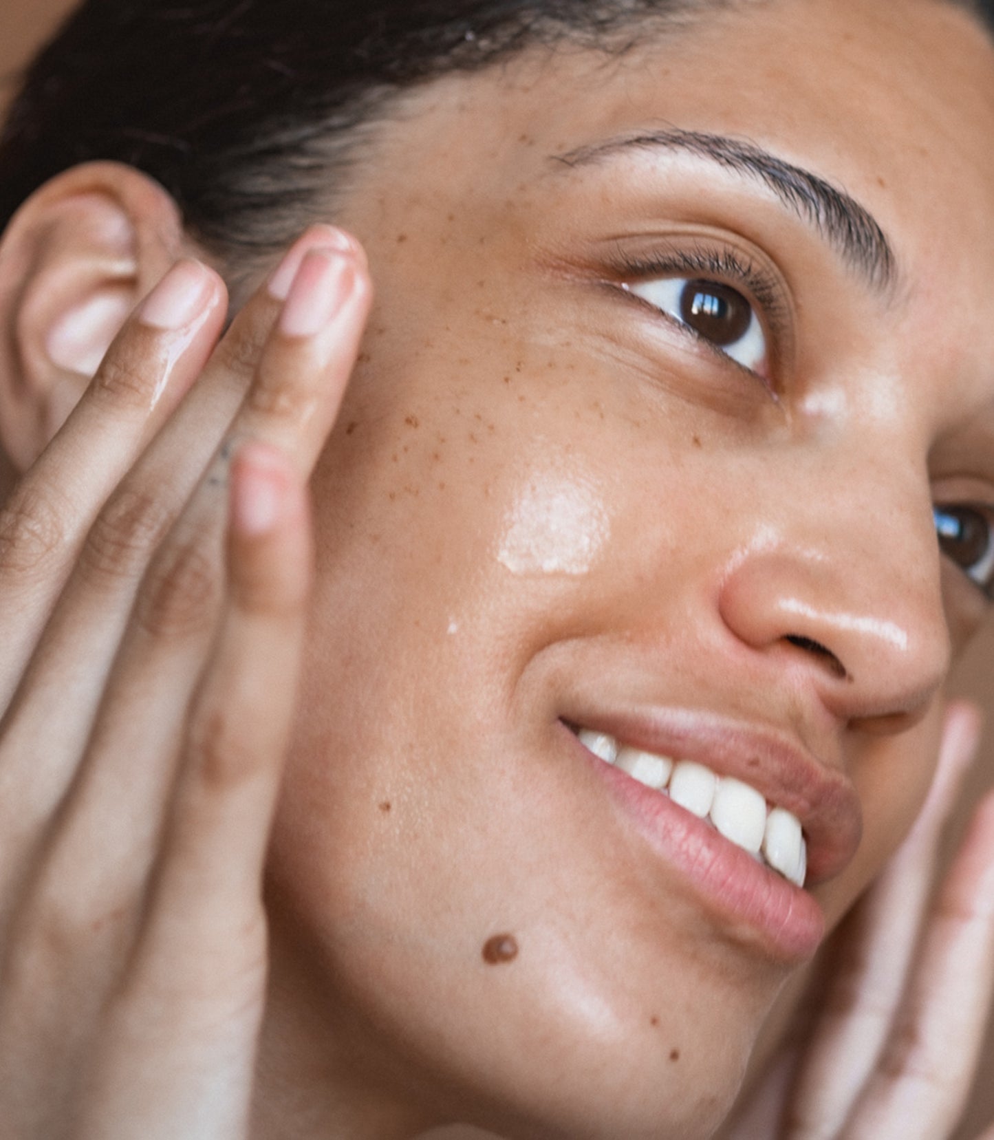 Close-up of a person applying cream to their face