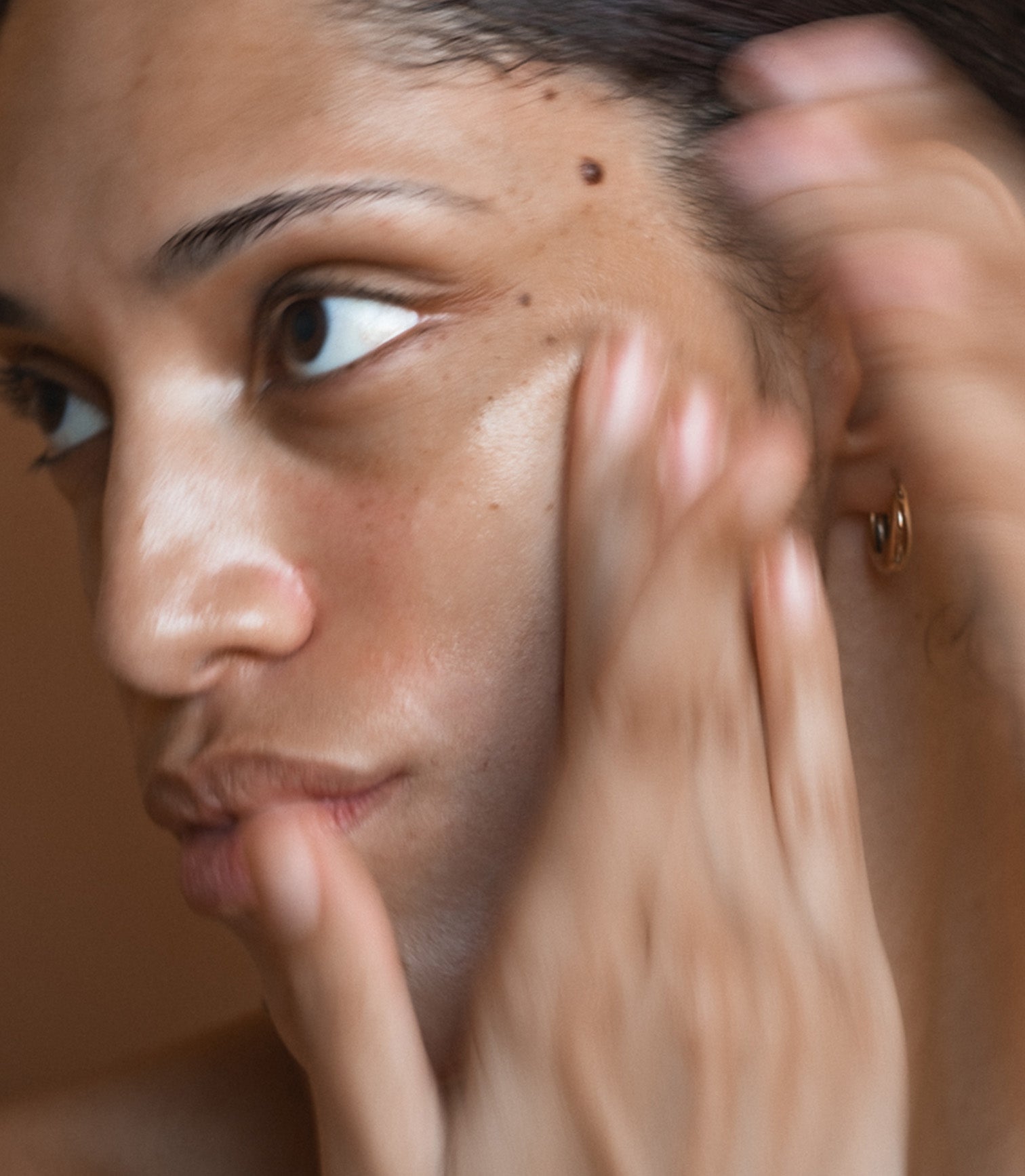 Close-up of a person applying makeup with a brush to their face.