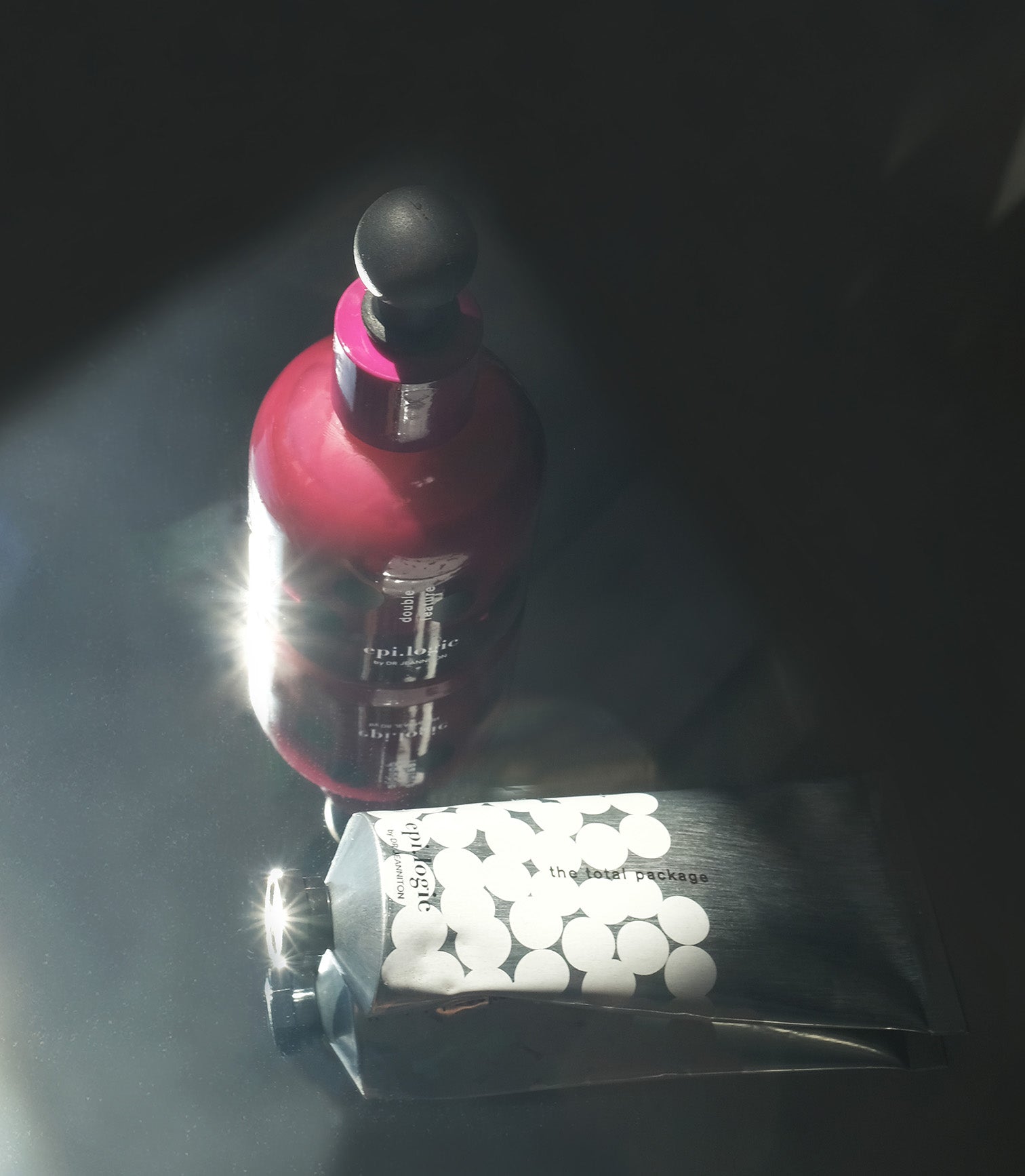 Bottle and packaging on a reflective surface with a dark background