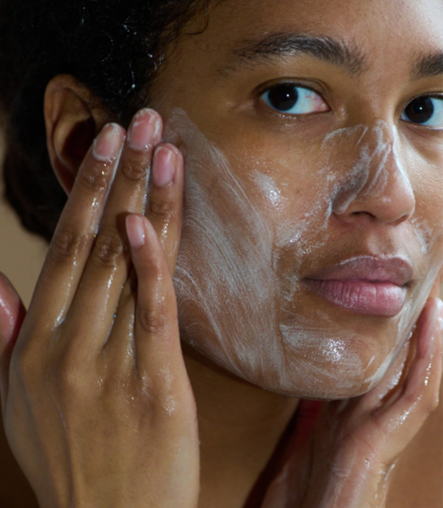 Person applying a facial mask to their face