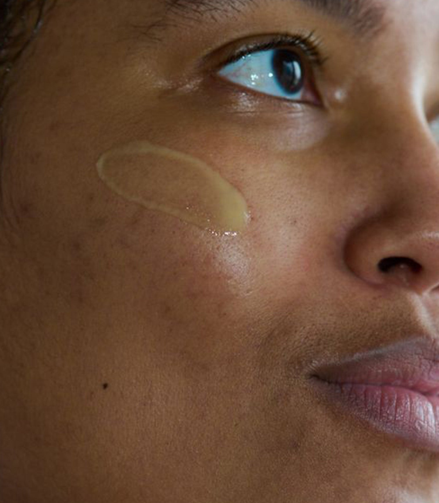 Close-up of a person's face with a cosmetic product applied to the skin.