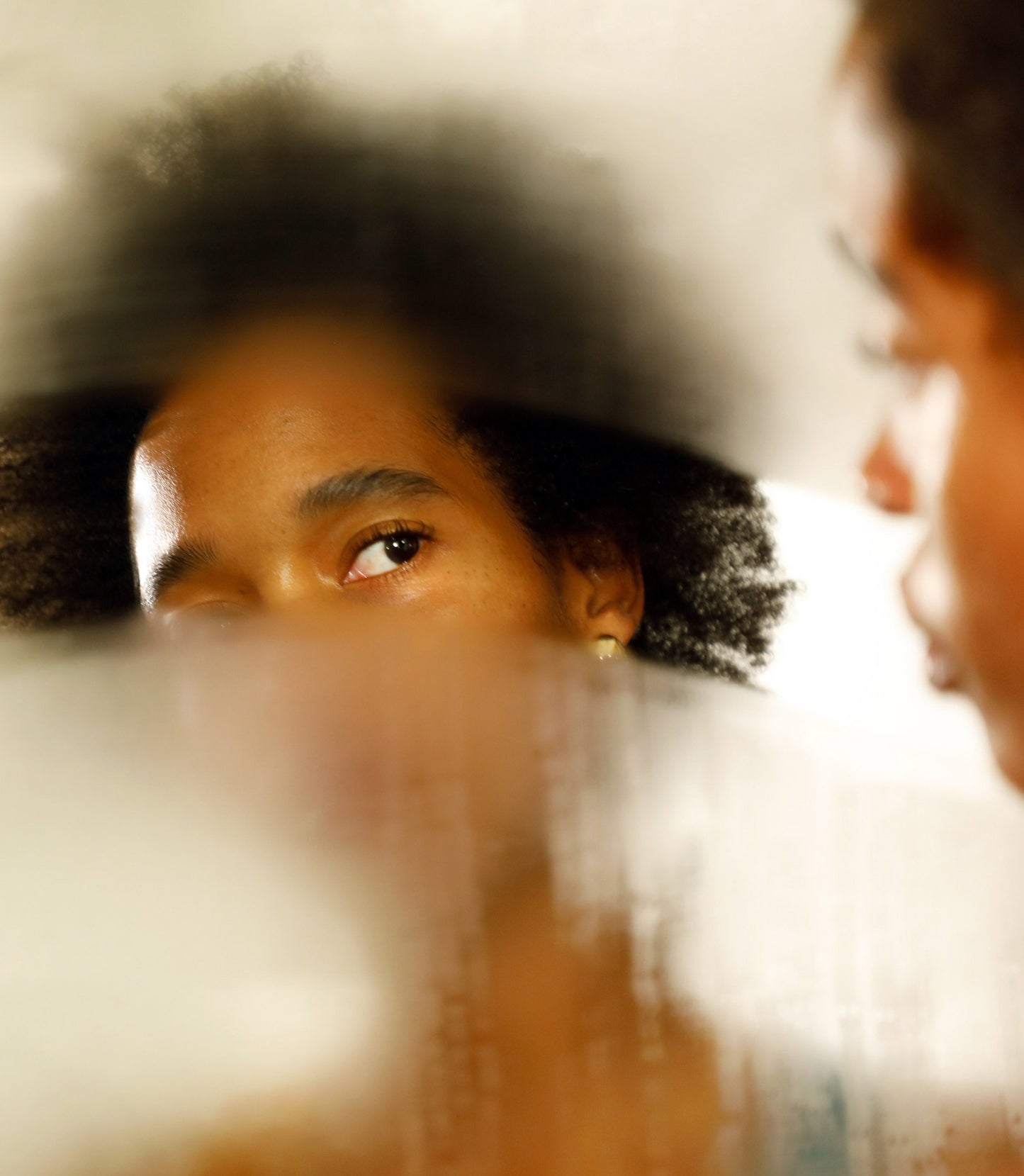 Woman looking in foggy mirror
