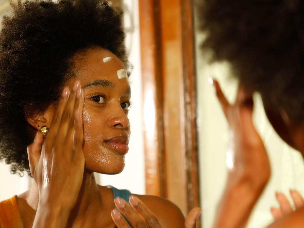 Woman applying product in mirror