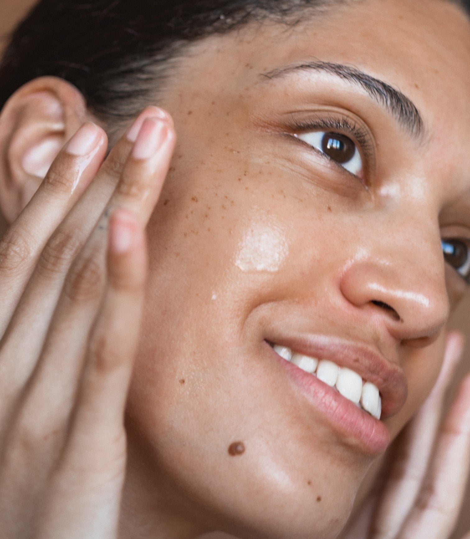 Close-up of a person applying cream to their face