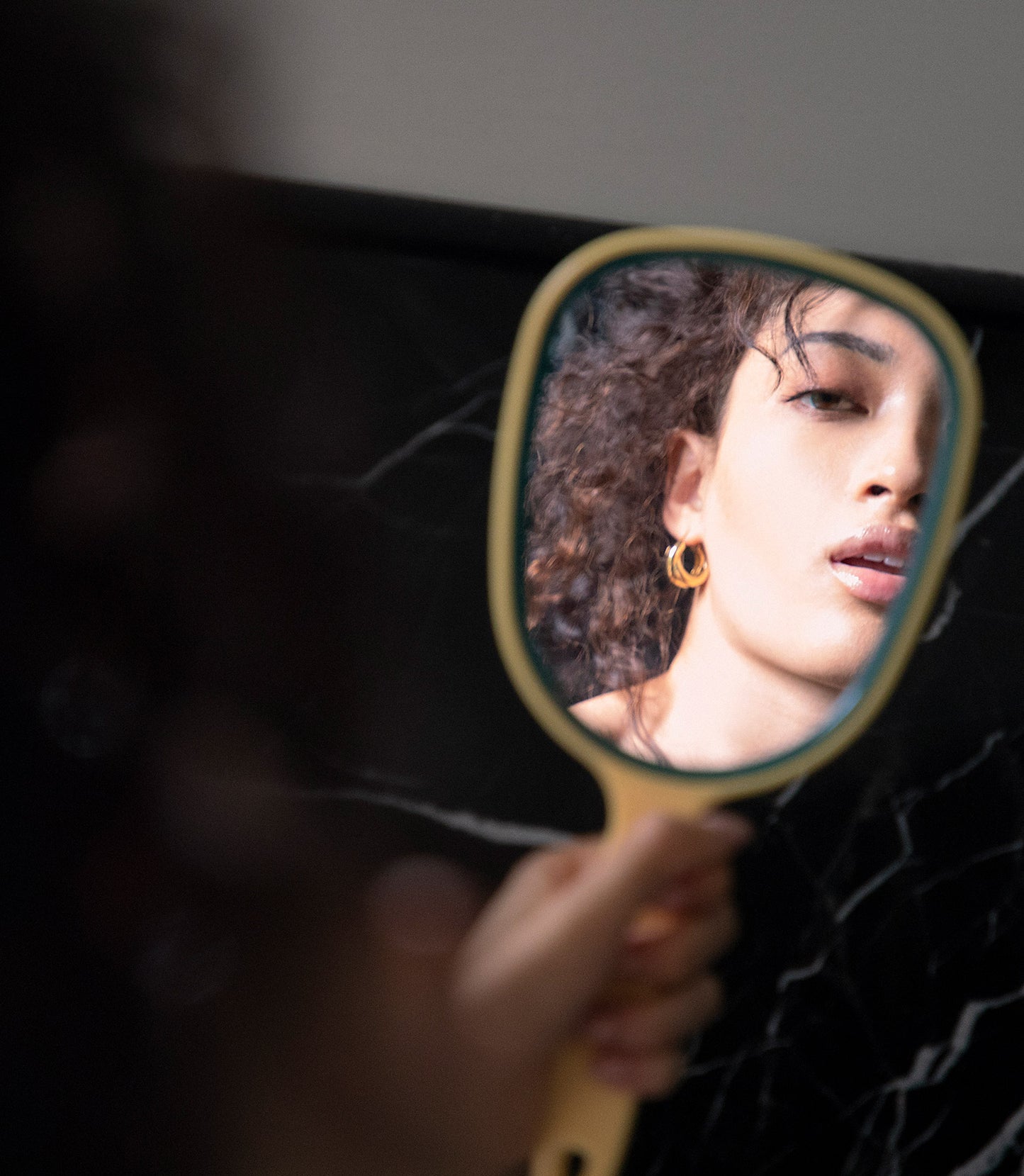 Woman looking in handheld mirror
